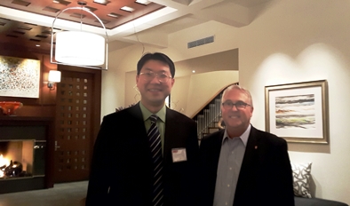 [photo of Dr. He with Chancellor Woodson]